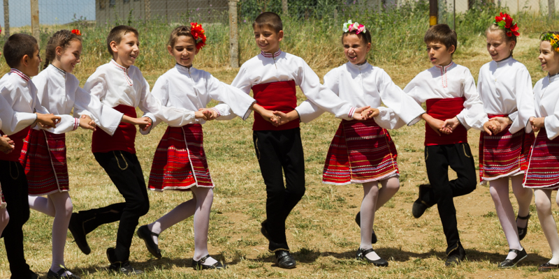 Bulgaarse kinderen in klederdracht dansen een traditionele rondedans